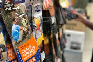 Bags of freeze dried food hanging on a display at REI.