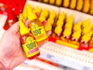 hand holding 2 yellowbird hot sauces in front of a target shelf