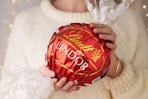 a woman holding a lindt lindor ball