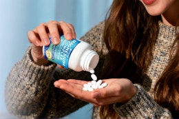 woman empty supplements into hand