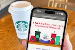 starbucks for life game on a phone next to a starbucks cup