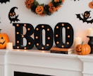 a black and orange LED "boo" sign on a mantle