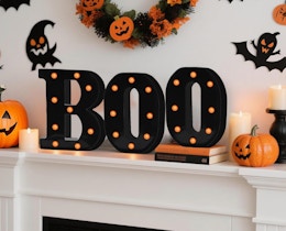 a black and orange LED "boo" sign on a mantle