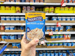 hand holding progresso soup in walmart aisle