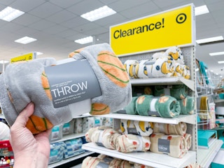 hand holding a throw blanket in front of target clearance signage