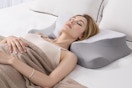 woman laying on grey/white cervical neck pillow