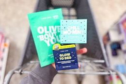 hand holding i dew care skincare products over a shopping cart