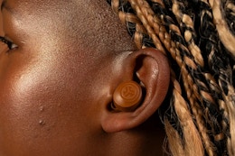 a woman wearing jlab earbuds