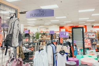 Interior of a TJ Maxx store Runway section showing signs for brands like Vince