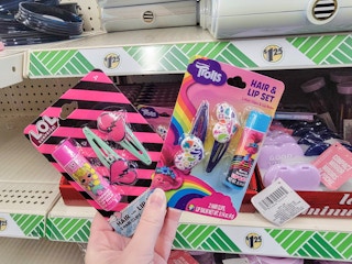 hand holding kids hair & lip sets with trolls or lol surprise