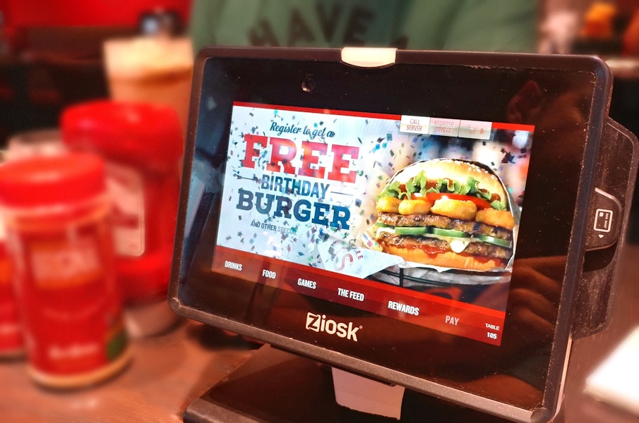 Photo of Red Robin table kiosk displaying an offer for a free birthday burger.