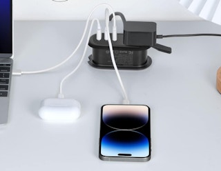 a power strip with airpods and a phone plugged in