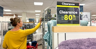 a woman grabbing an item off the top shelf in the clearance area of jcpenney
