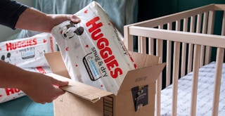 a person taking huggies diapers out of an amazon box