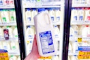hand holding a half gallon of kroger milk
