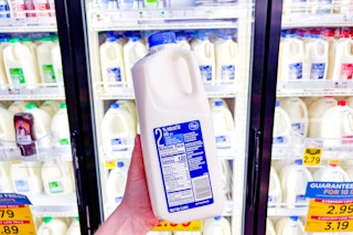 hand holding a half gallon of kroger milk