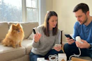 a couple unboxing arlo cameras near a pomeranian