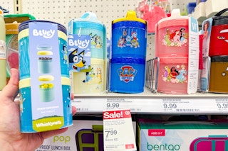 hand holding a bluey whiskware stackable food jar set in front of a shelf