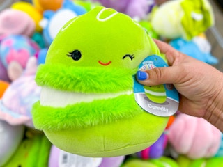 a person holding up a squishmallow at five below