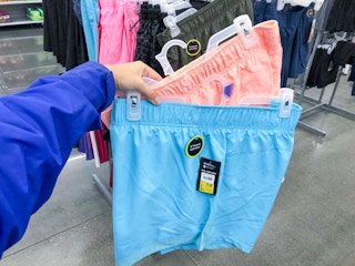 two pairs of avia running shorts held in up by hangers