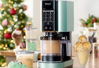 Mint Ninja Creami surrounded by ice cream in front of a Christmas tree. 