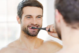 Man using the Aquasonic Black Series Ultra Whitening Toothbrush.