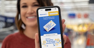 A woman holding up a phone displaying the Mother's Day Campaign page on Walmart's website