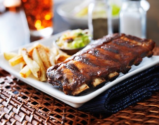 Barbecue ribs on a plate with fries.