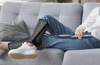a person on a couch wearing leg massagers