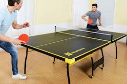 Lifestyle image of the MD Sports Indoor Table Tennis Pong Table being played with by two adults
