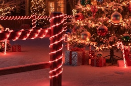 candy cane ropes around a fence outside a house 