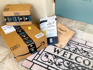 Amazon boxes sitting next to a doorstep.