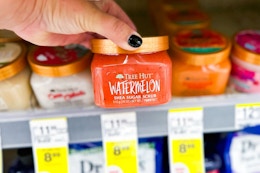 person grabbing a tree hut body scrub from the shelf