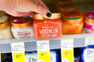 person grabbing a tree hut body scrub from the shelf