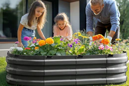 family planting flowers together in garden bed