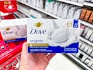 hand holding a dove bar soap 4-pack in front of parked target cart