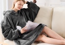 a person on a couch wearing a blanket hoodie