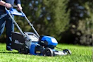 Lifestyle image of a Kobalt Push Mower being used to cut grass