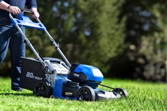 Lifestyle image of a Kobalt Push Mower being used to cut grass