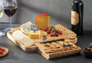 a Charcuterie board on a table next to glass of wine