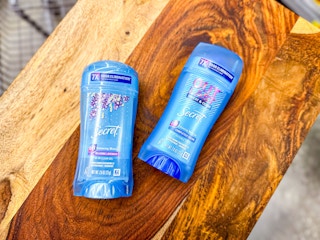two blue sticks of Secret deodorant on a wooden board