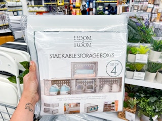 A hand holding a Room to Room stackable storage boxes at Five Below