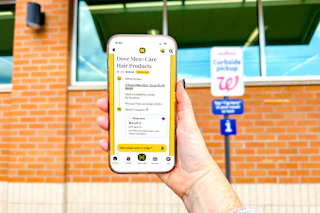 hand in front of a walgreens pickup sign holding a smartphone displaying a kcl app 1-clip deal