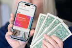 someone holding up the YouGov app and cash