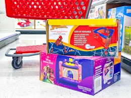 2 bounce houses sitting in front of a parked target cart