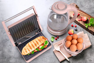 Lifestyle image of the Cook with Color kitchen appliance set (panini press, electric settle and egg boilier)