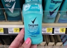 hand holding up bottle of Degree deodorant at Dollar General in front of store shelf
