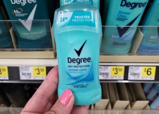 hand holding up bottle of Degree deodorant at Dollar General in front of store shelf