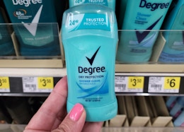 hand holding up bottle of Degree deodorant at Dollar General in front of store shelf