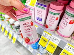 hand holding nature's bounty hair, skin, and nails gummies in walgreens